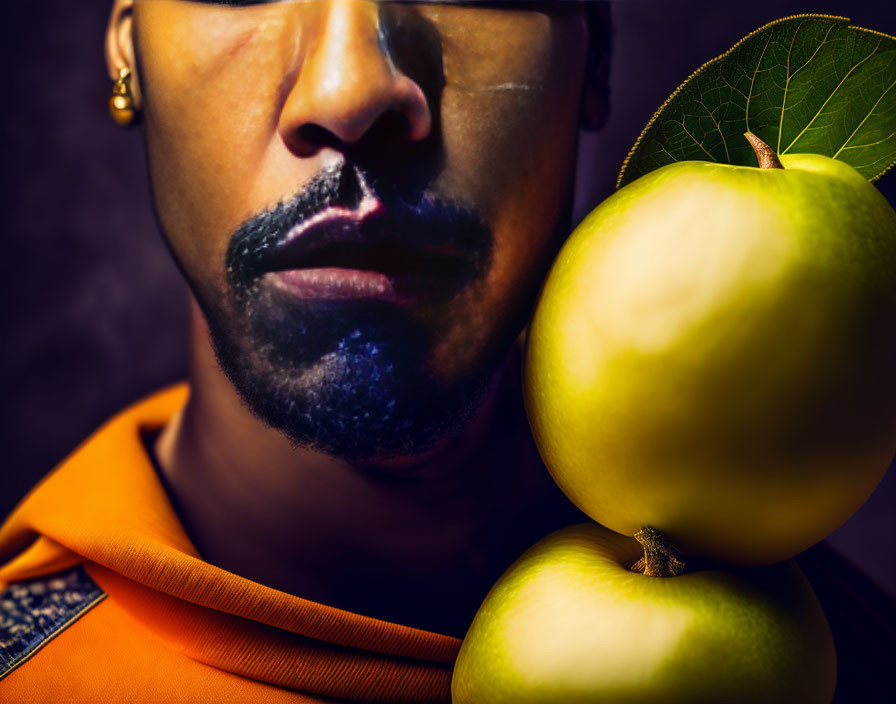 Man with beard and apple on shoulder against dark background