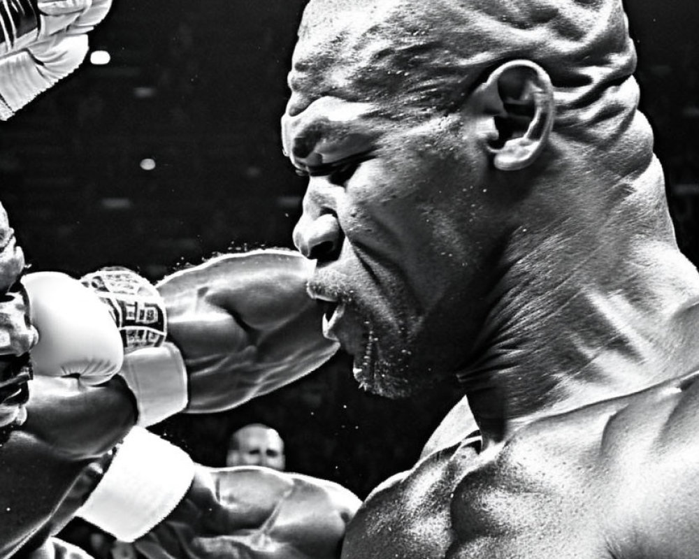 Monochrome close-up of boxer punched in match, tense expression