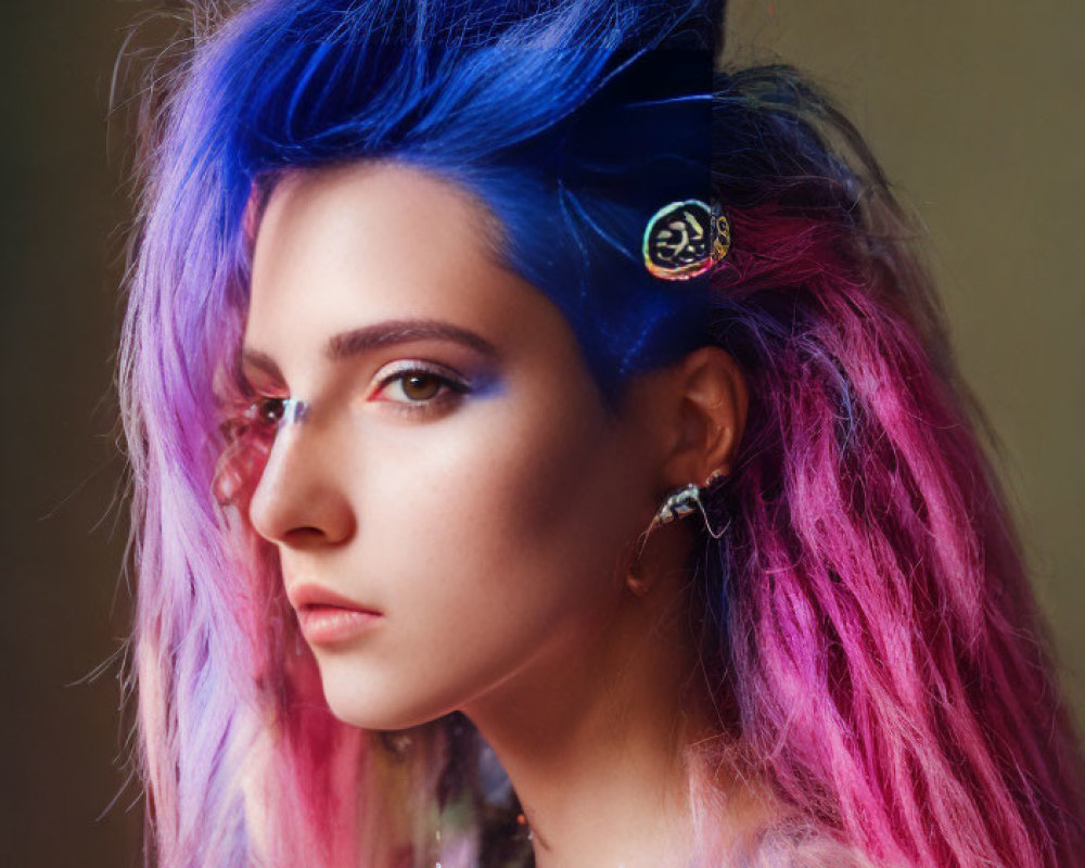 Portrait of a person with vibrant blue and pink hair and unique circular earring