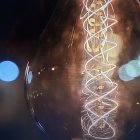 Double Helix Filament Illuminated by Blue Bokeh Circles on Dark Background