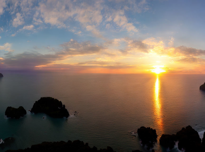 Calm ocean sunset with scattered islands and golden sun reflection