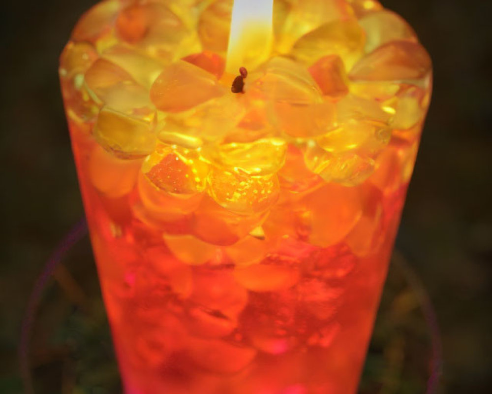 Glass Ice Candle Emitting Warm Orange Glow on Dark Background