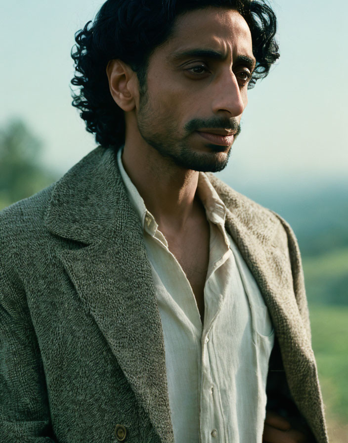 Curly-Haired Man in Beige Shirt and Brown Coat Outdoors