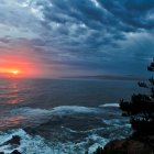 Scenic lighthouse on rocky outcrop at sunset