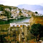 Scenic coastal village with white houses, beach, boats, and mountain view