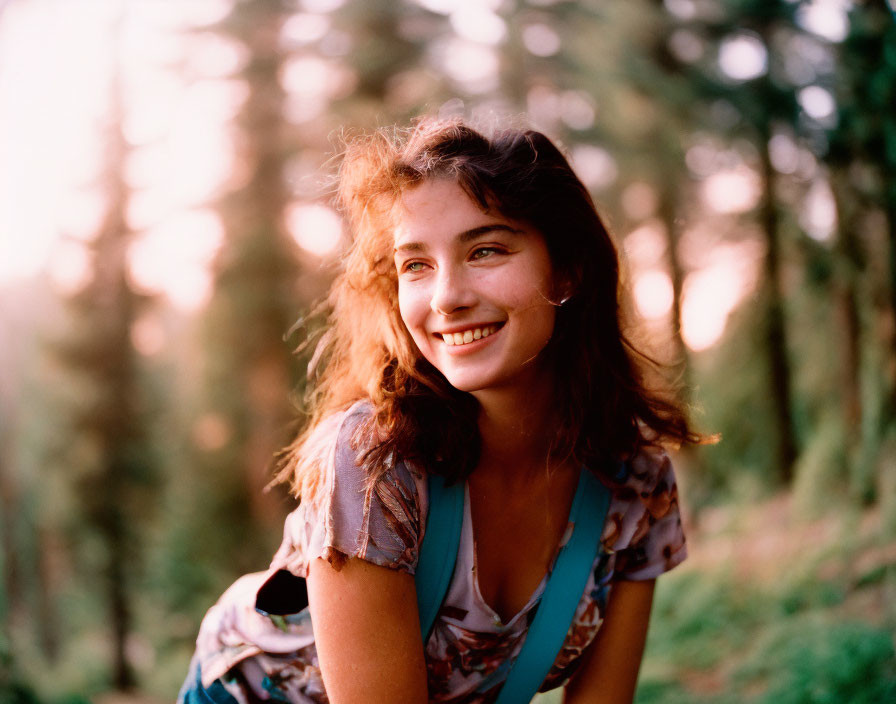 Smiling woman in patterned top in sunlit forest