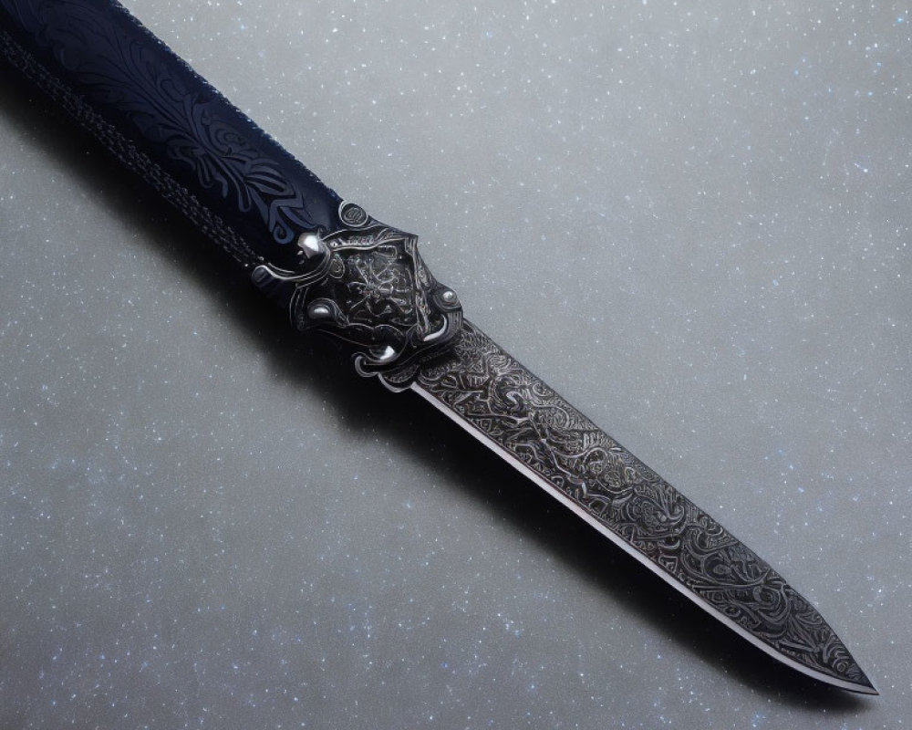 Intricately patterned ornate knife on speckled grey background