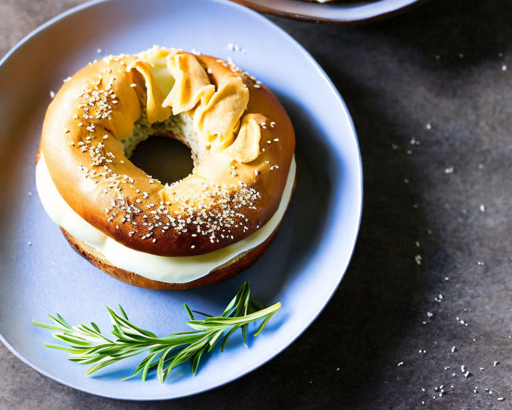 Freshly Prepared Bagel with Cream Cheese and Rosemary on Dark Surface