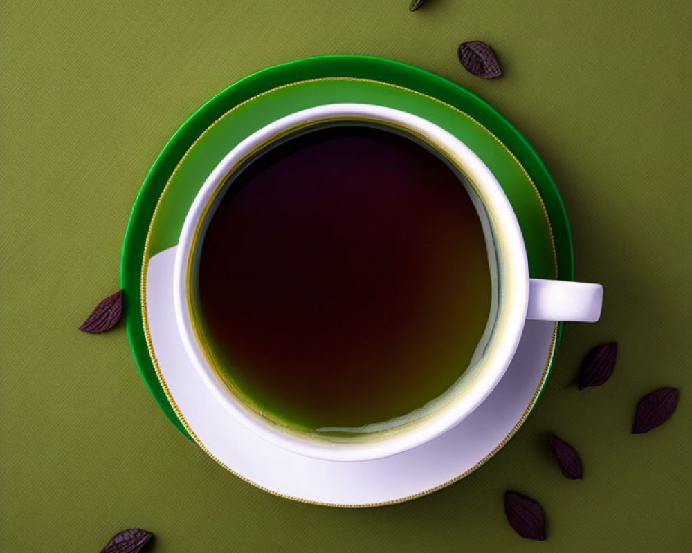 White Tea Cup on Green Saucer with Chocolate Pieces on Green Background