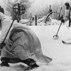 Snowy battle scene: soldiers aiming and charging with bayonets among pine trees