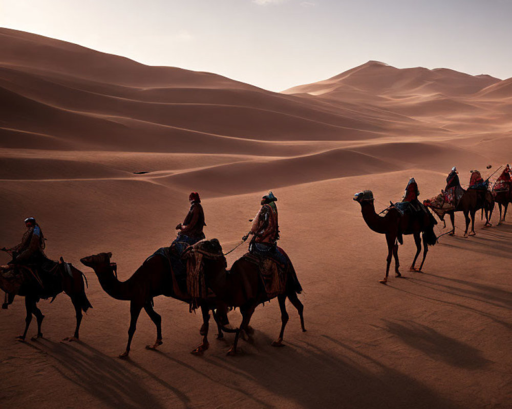 Colorful attired camel riders cross sandy desert dunes at dusk