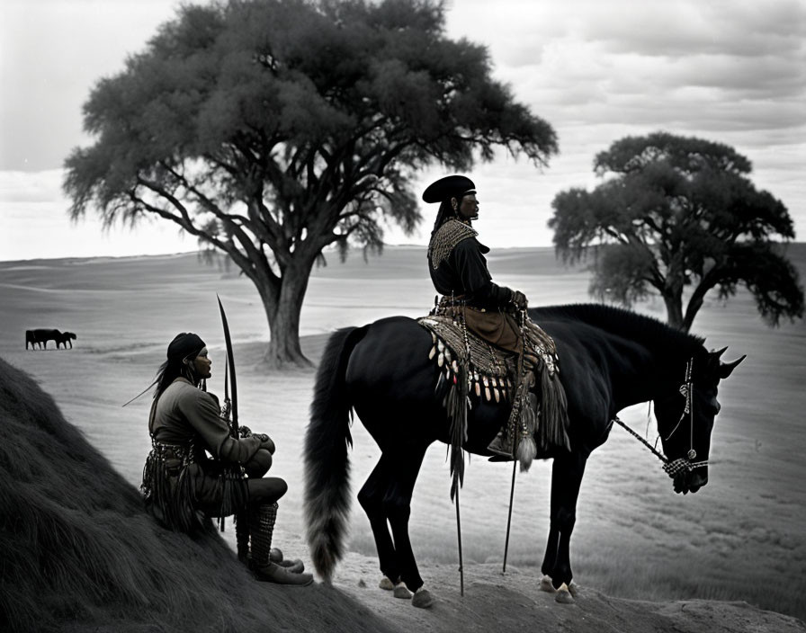 Two people in traditional clothing on grassland with horse, cattle in background