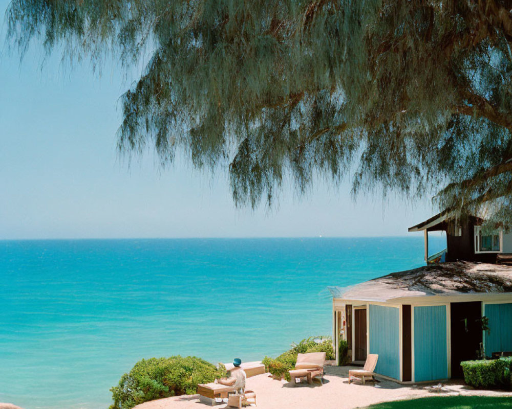 Tranquil beach scene with shaded lounging area by cabin