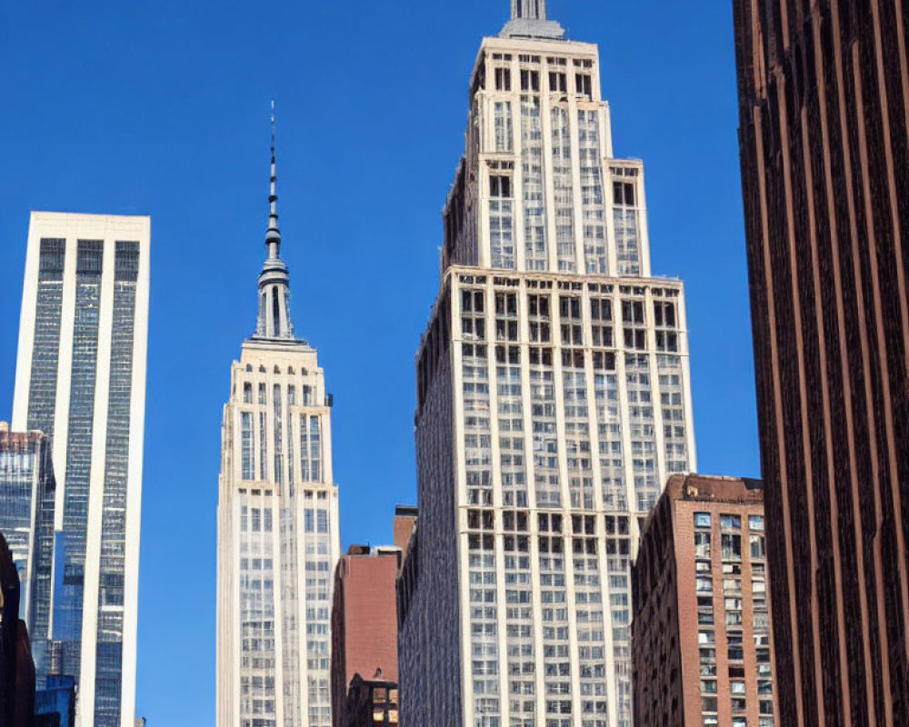 City skyline with Empire State Building and high-rise buildings against clear blue sky