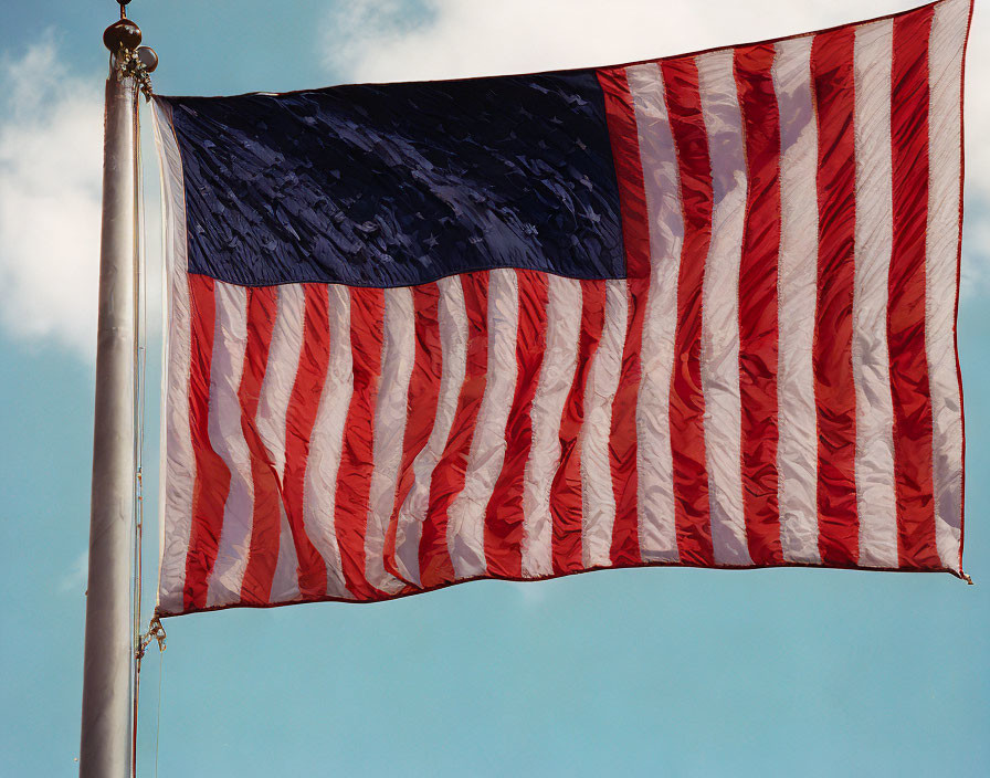 Patriotic American flag waving under clear sky