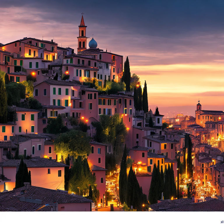 Twilight hillside town with illuminated buildings, cypress trees, and church spire.