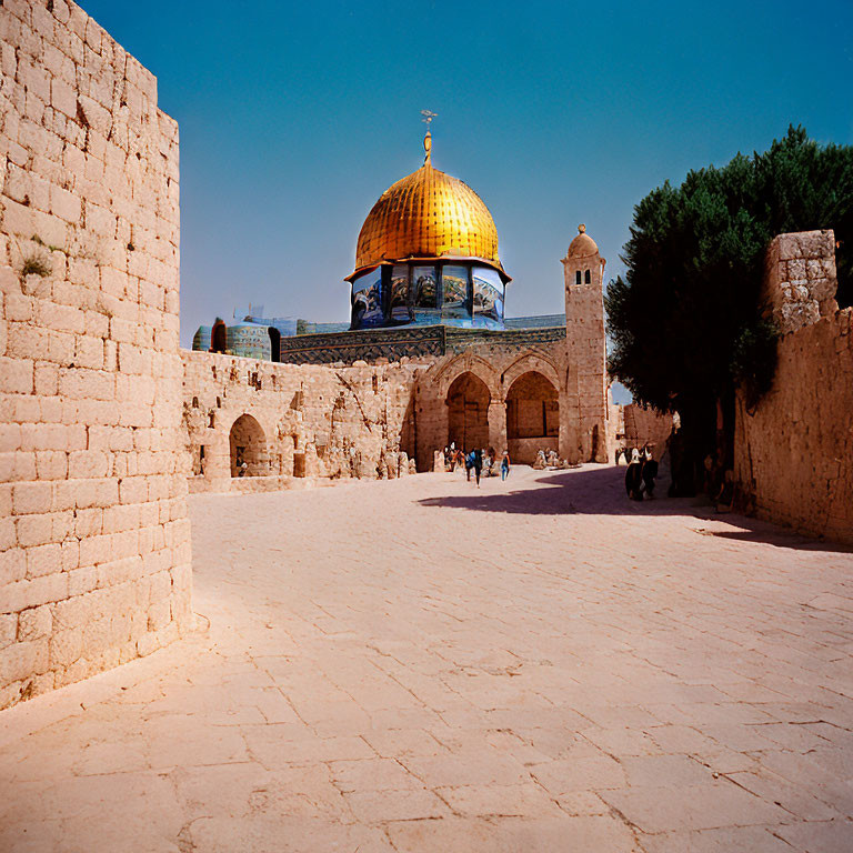 Historic stone walls and golden dome at Dome of the Rock courtyard.