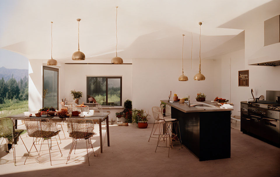 Modern sunlit kitchen with island, pendant lights, stainless steel appliances, mountain view dining area