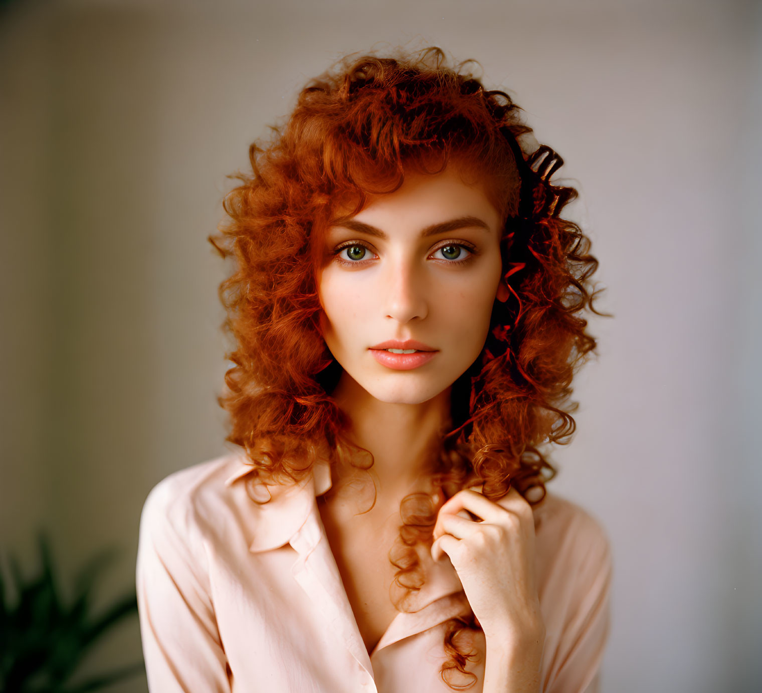 Curly Red-Haired Woman in Light Pink Blouse and Delicate Earring