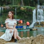 Woman in White Dress and Sunglasses Poses by Classic Green Car in Field