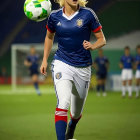 Colorful digital artwork: Woman in vibrant soccer uniform with flowing patterns, holding ball on grass