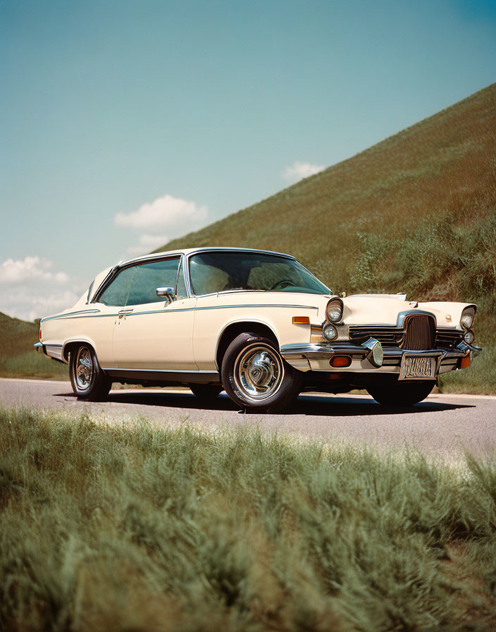 Classic Two-Tone Car Parked by Roadside with Green Hills and Blue Sky