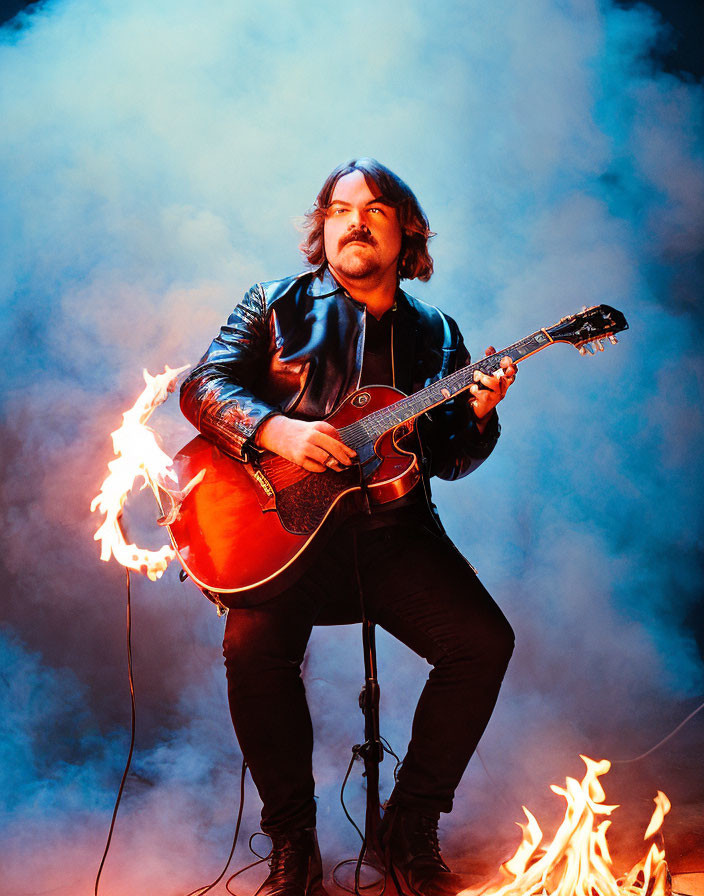 Musician Playing Guitar Surrounded by Flames on Blue Smoky Background