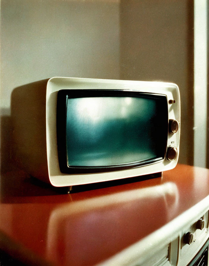 Vintage television set with dials on table in room with natural light