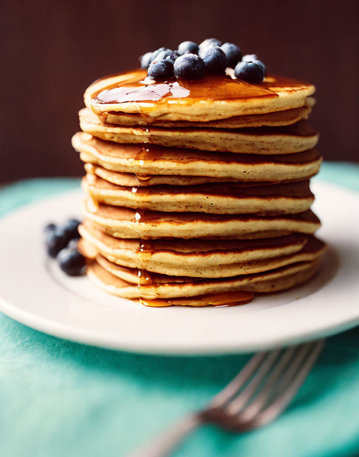 Fluffy Pancakes with Blueberries and Maple Syrup on White Plate