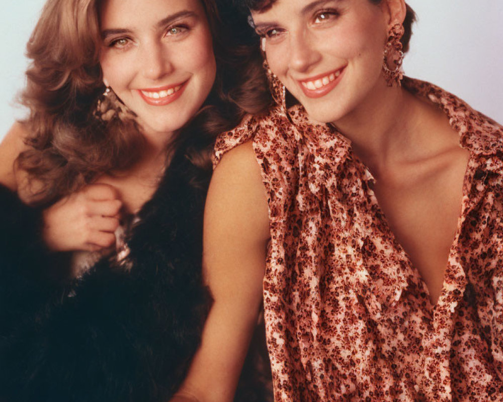 Two women posing closely, one blond in fur, the other with dark curly hair in leopard print top