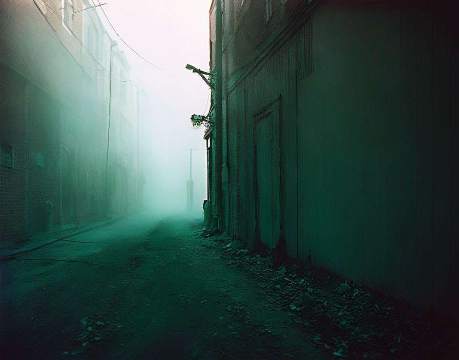 Foggy urban alley with dilapidated buildings and streetlight