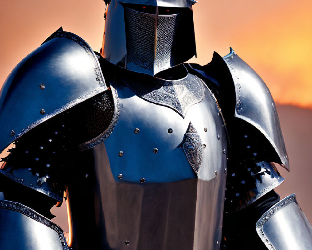 Medieval knight in full armor against orange sky