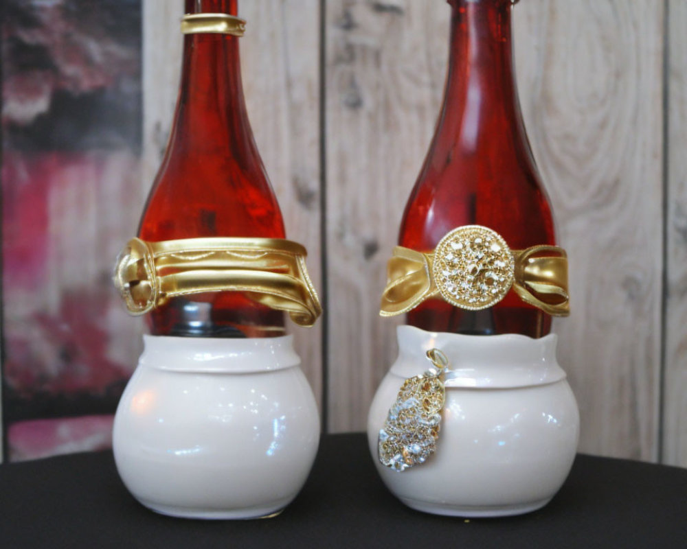 Decorative perfume bottles: white bases, red tops, one with gold ribbon, one with jeweled
