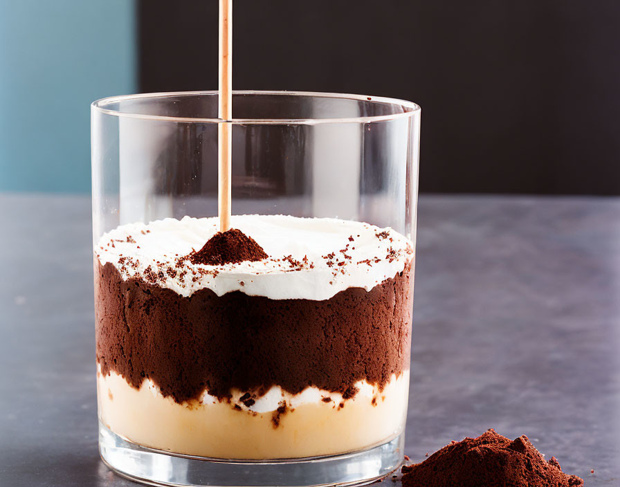 Layered Tiramisu Dessert with Cocoa Powder in Clear Glass