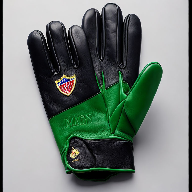 Two-toned leather gloves: black with crest emblem, green with embroidered initials and golden insignia