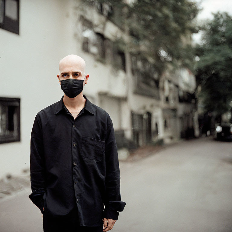 Bald Person in Black Mask and Shirt on Urban Street