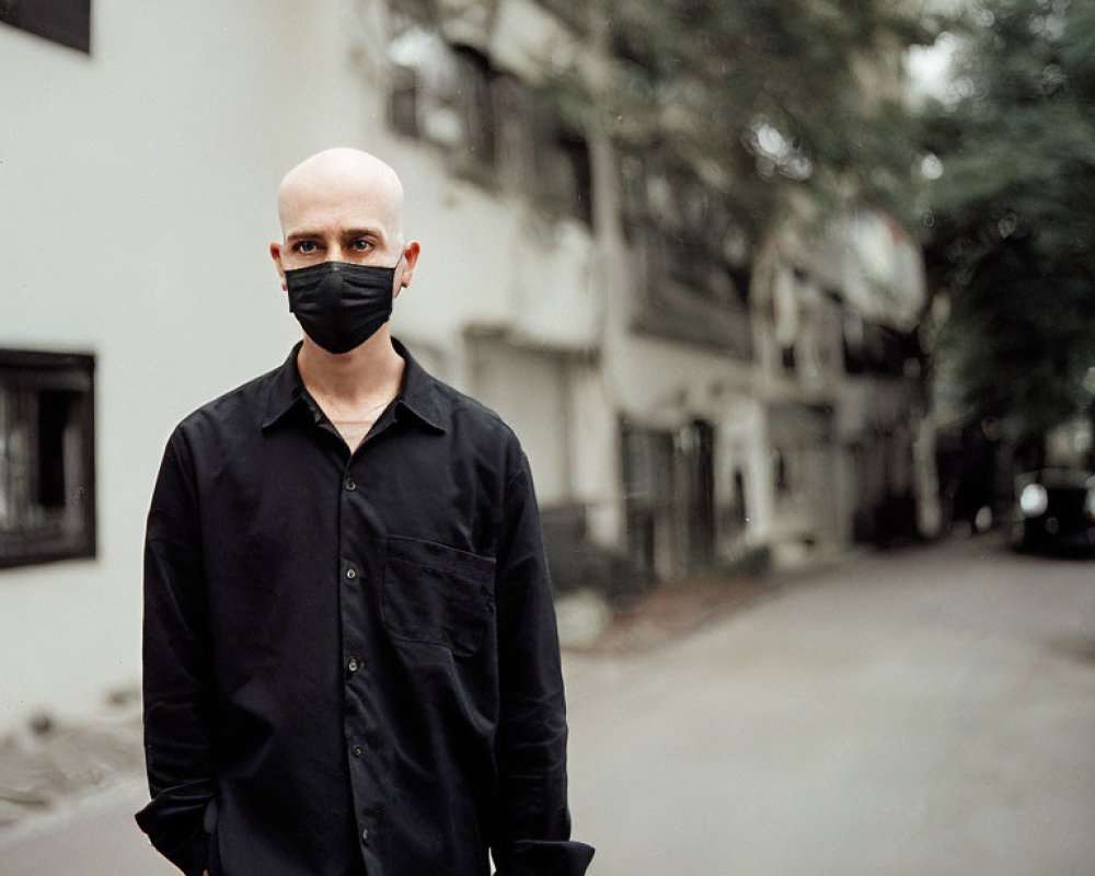 Bald Person in Black Mask and Shirt on Urban Street