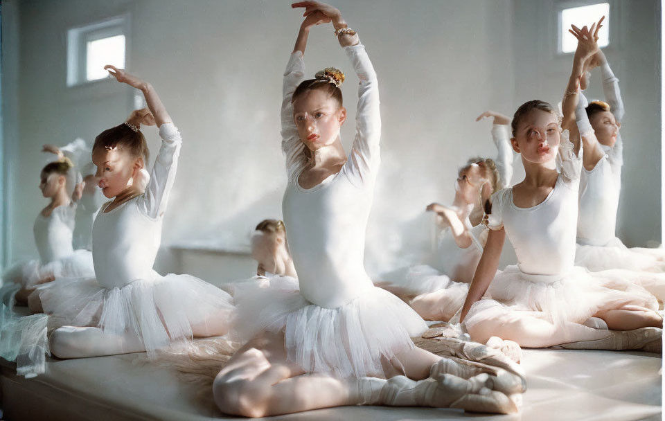 Ballet dancers in white tutus practicing in studio mirror