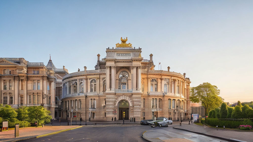 Neoclassical building with golden statues and manicured hedges