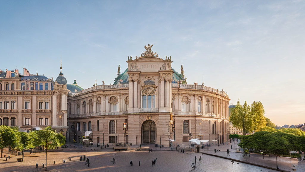 Grand facade and sculptures of an elegant building at sunset with pedestrians.