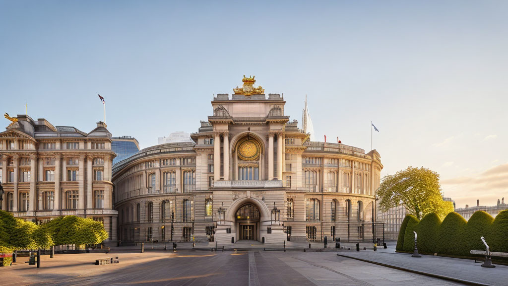 Classical building with arched entrance, columns, sculptures, and flags at dusk