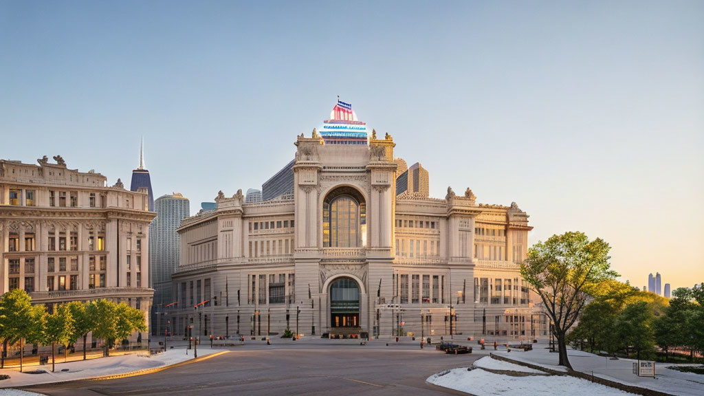 Neoclassical building with central arch and symmetrical wings in urban sunset scene.