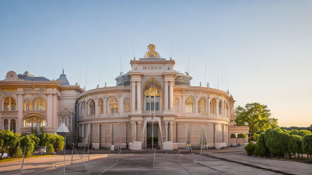 Classical building with central dome and intricate façade details amid trees at dusk