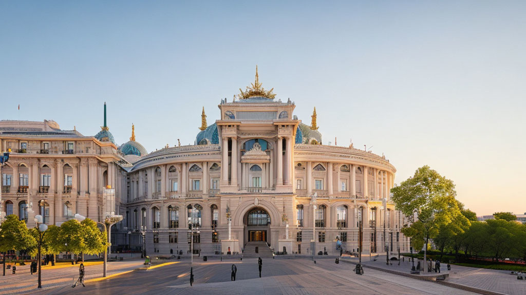 Ornate golden statue atop grand classical building with large windows