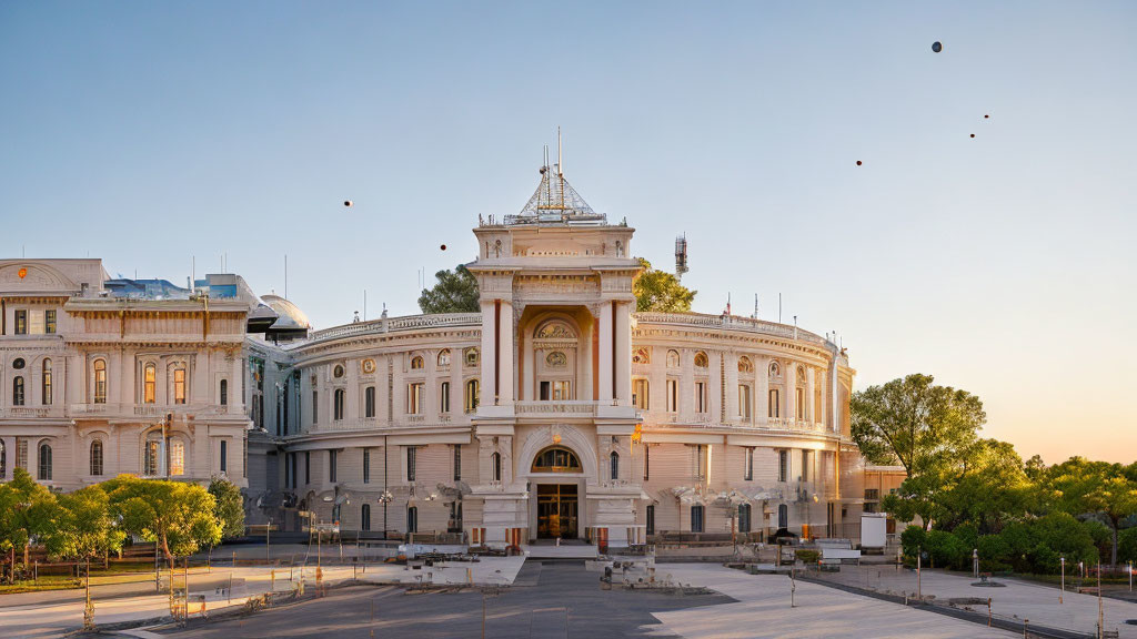 Neoclassical building with grand entrance and ornate detailing under clear sky