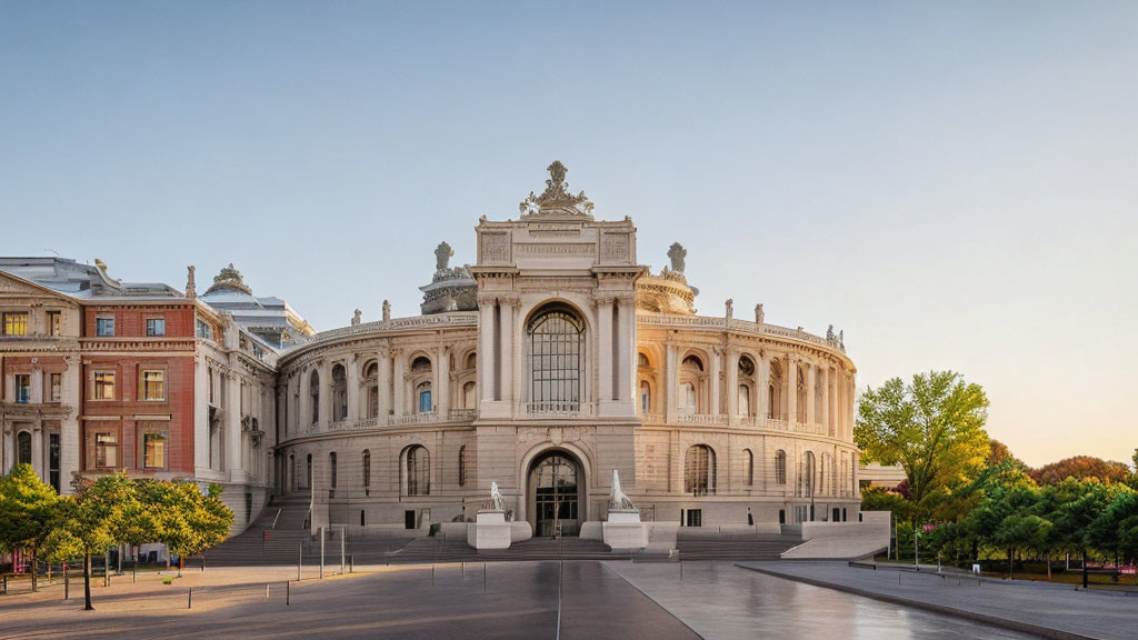 Ornate facade with sculptures on classical-style building among modern structures and trees