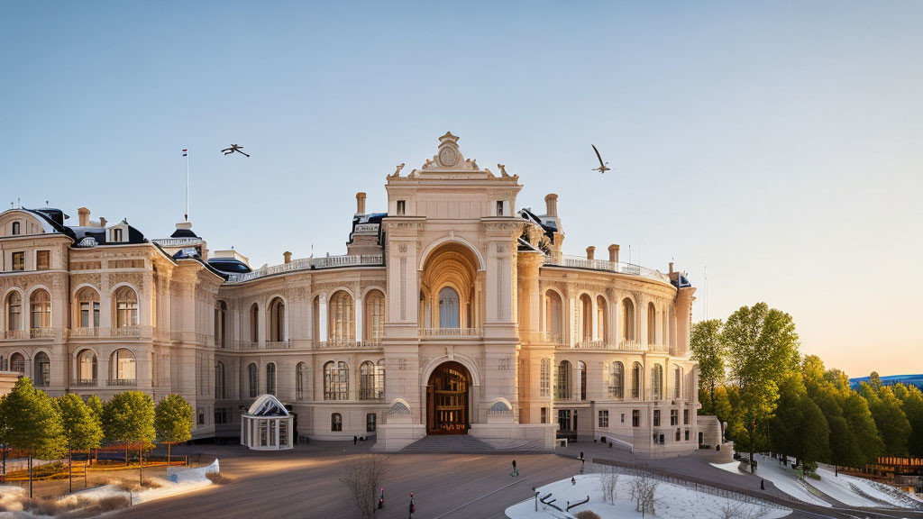 Ornate building with grand entrance and birds in clear dusk sky