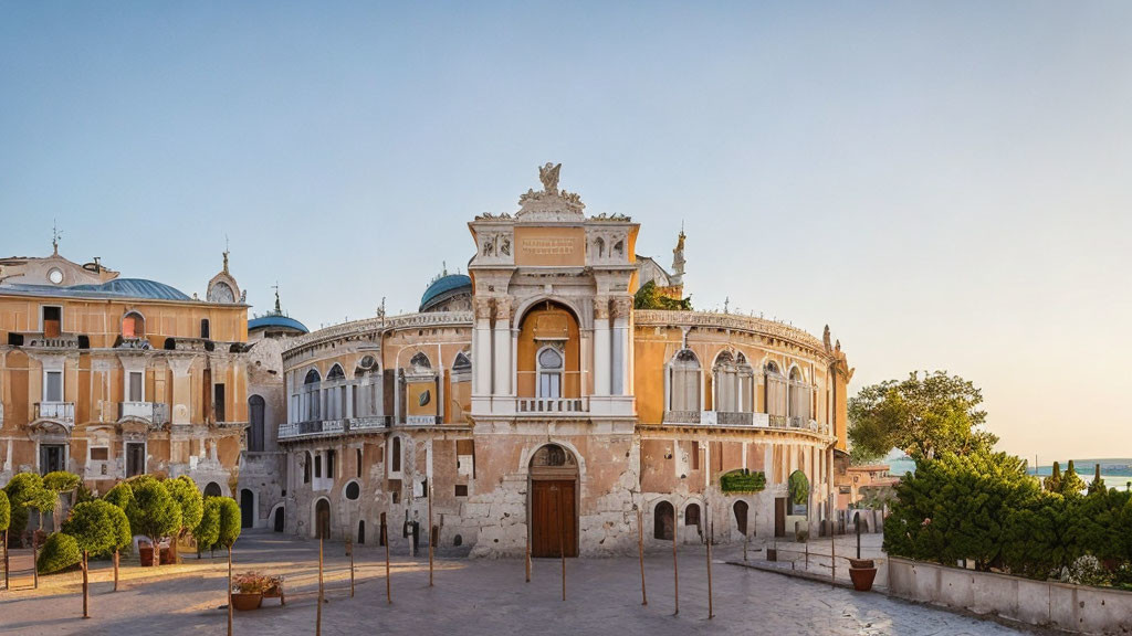 Historic European Building with Arched Windows and Statues at Golden Hour