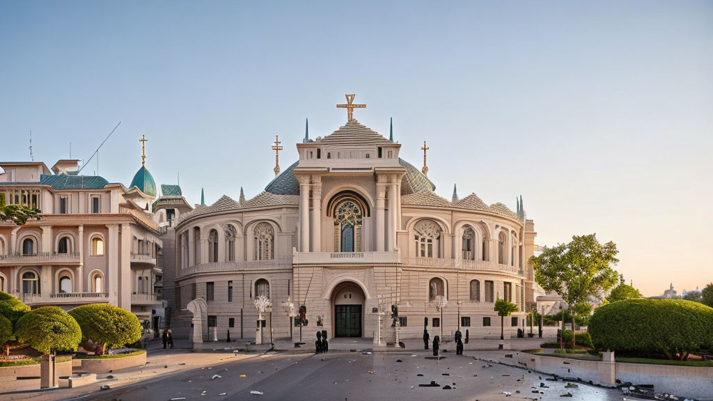 White building with domes and cross, people gathered at dusk or dawn