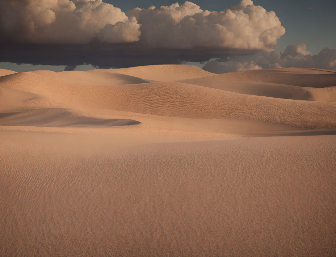 Cloudy Sky Over Undulating Sand Dunes with Shadows